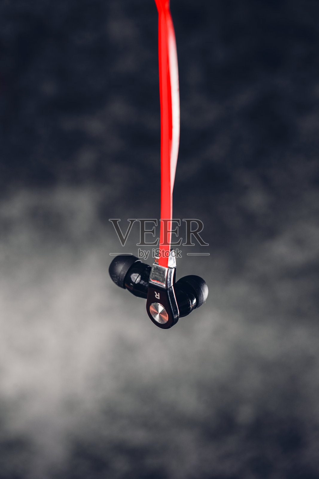 黑色耳机和红色的电线在灰色的背景上照片摄影图片