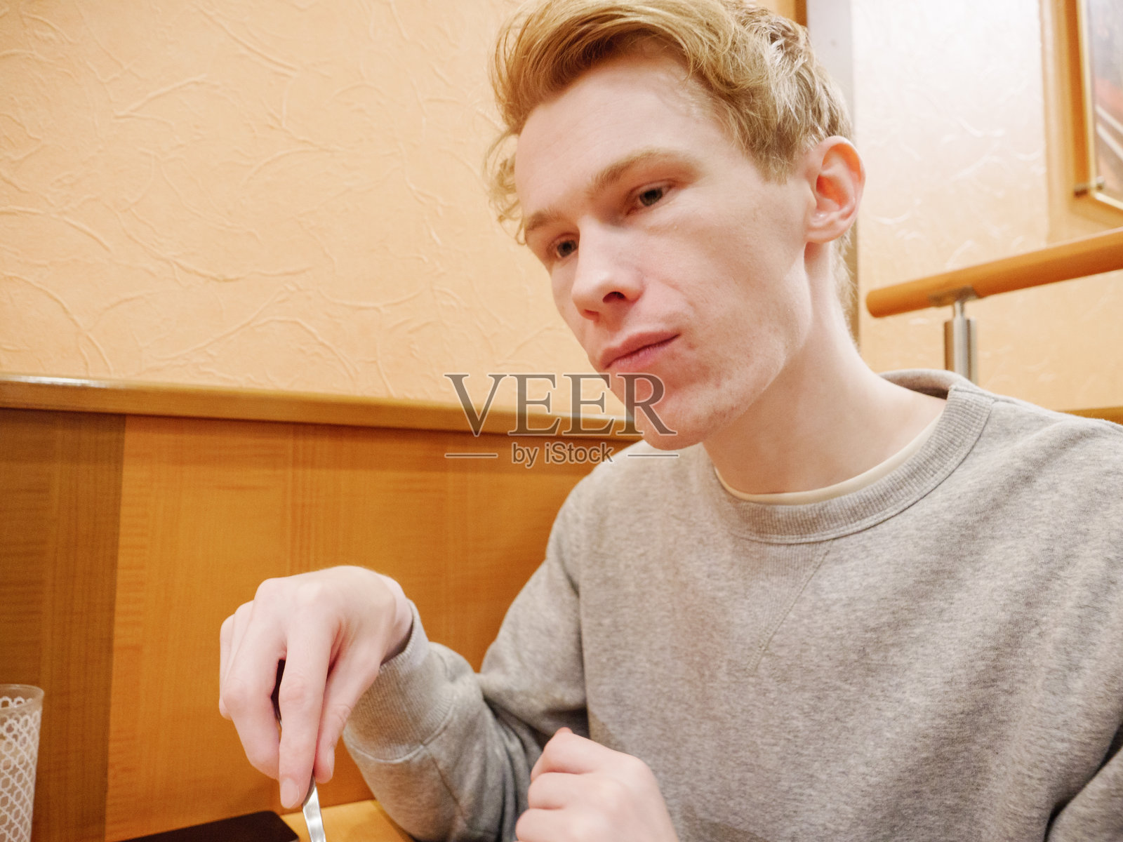 一个悲伤的年轻人独自在餐馆里照片摄影图片