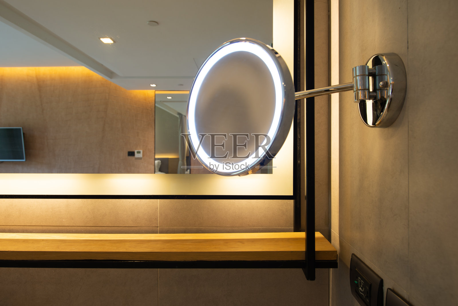 酒店浴室里带灯的圆形化妆镜照片摄影图片