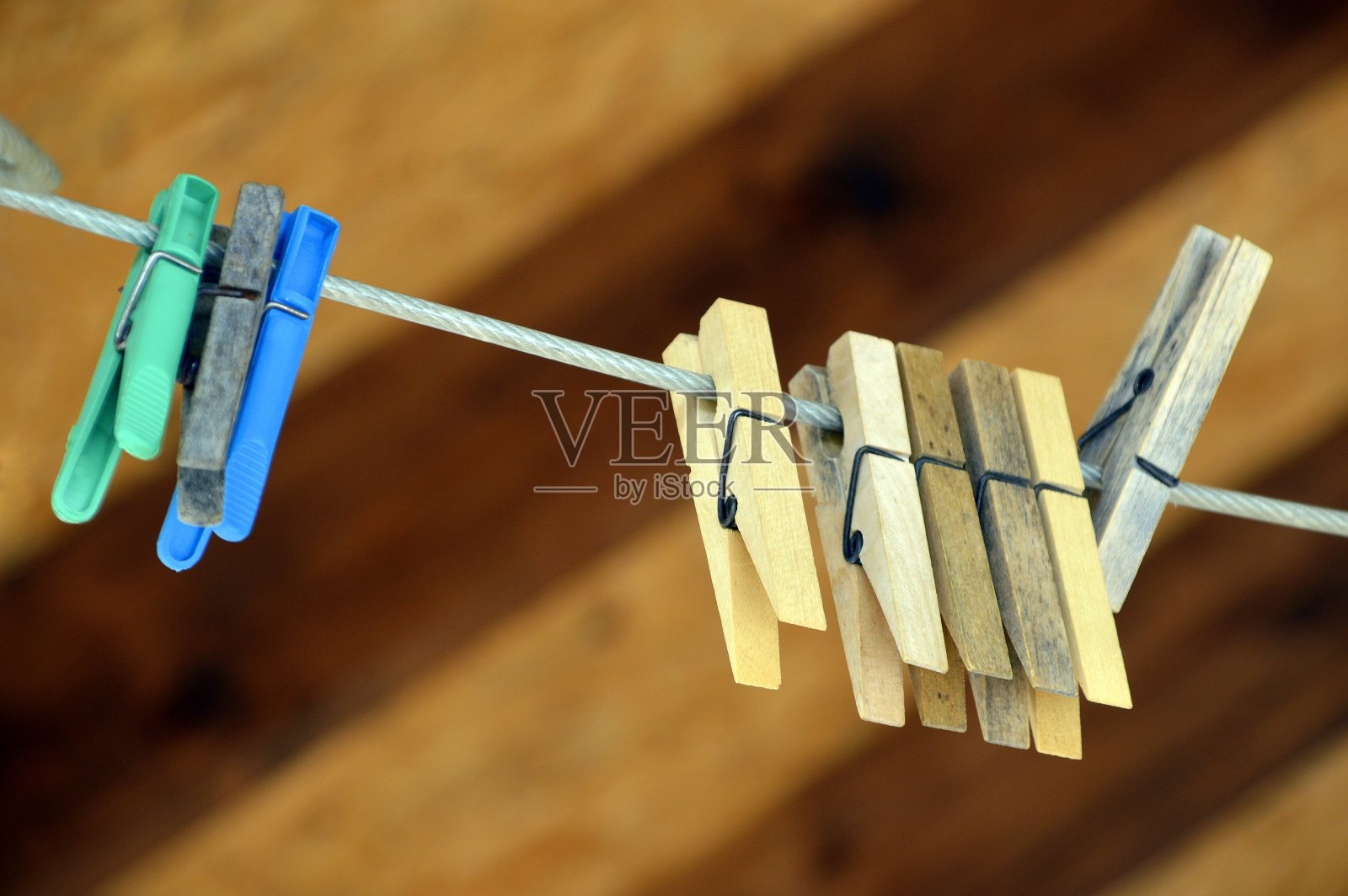 概念是爱和没有人陪伴的团聚。在木制背景上的绳子上的晾衣夹。中间的晒衣夹在焦点照片摄影图片