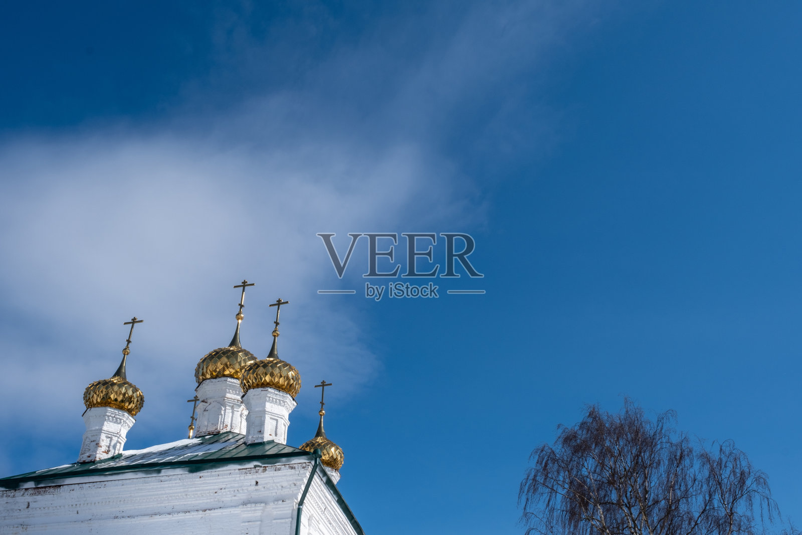 金色的圆顶，白色的石头教堂的十字架，映衬着蓝色的天空。照片摄影图片