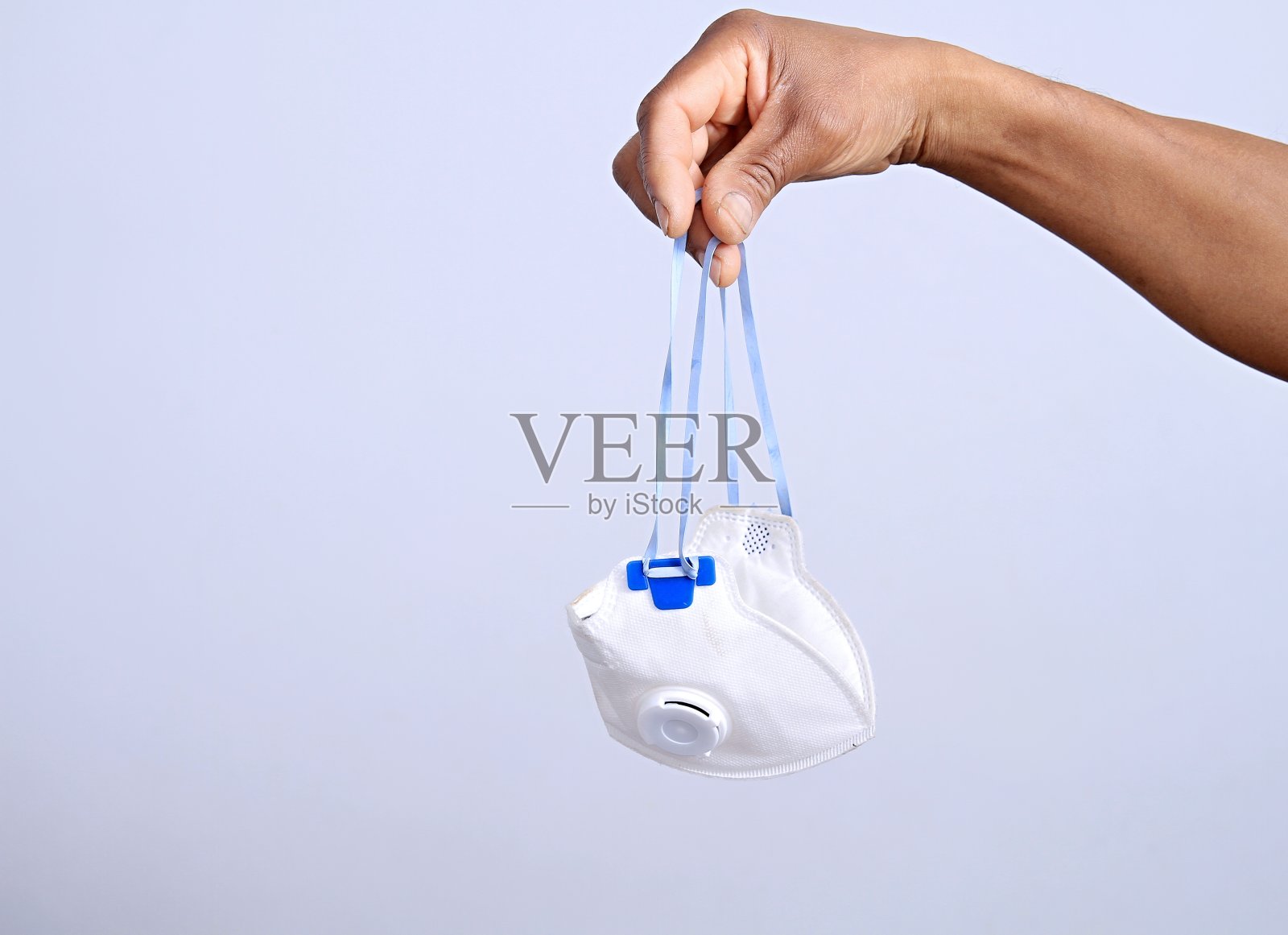 COVID-19冠状病毒大流行疫情爆发时，手持防尘口罩抗击疾病库存照片照片摄影图片