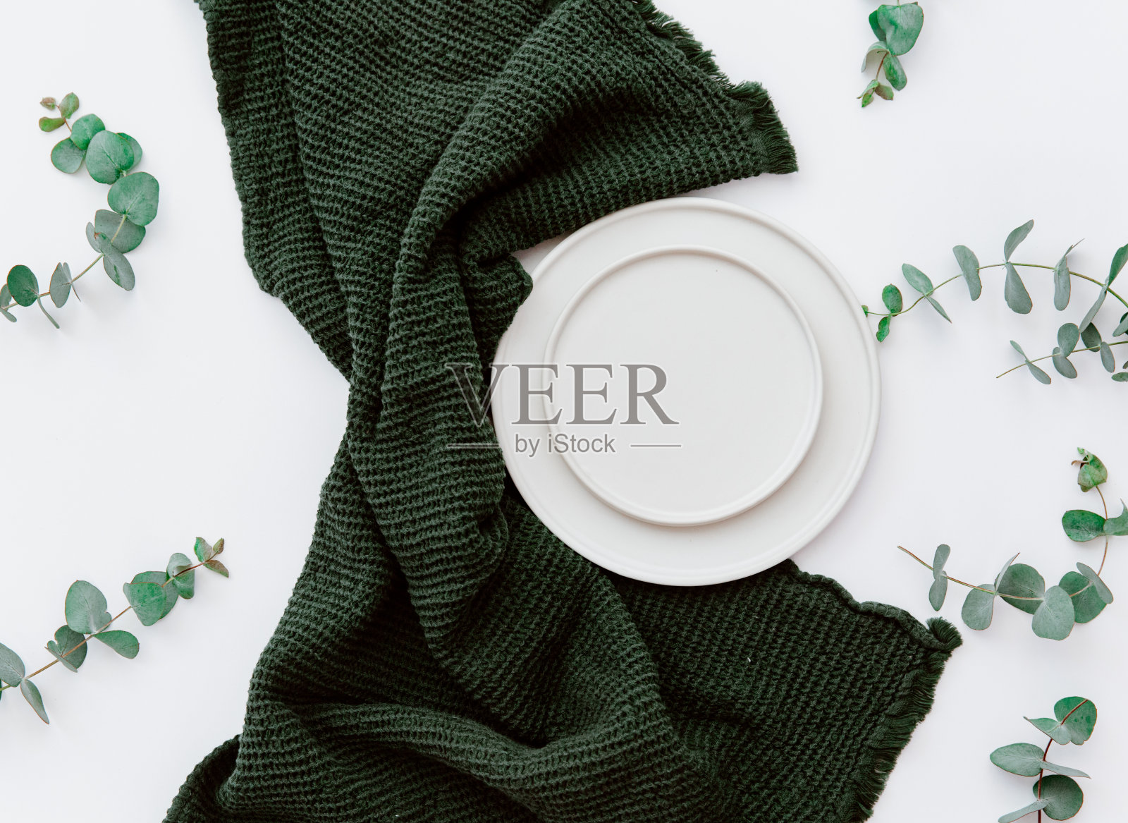 餐桌设置与花卉装饰和绿色餐巾在白色的背景照片摄影图片