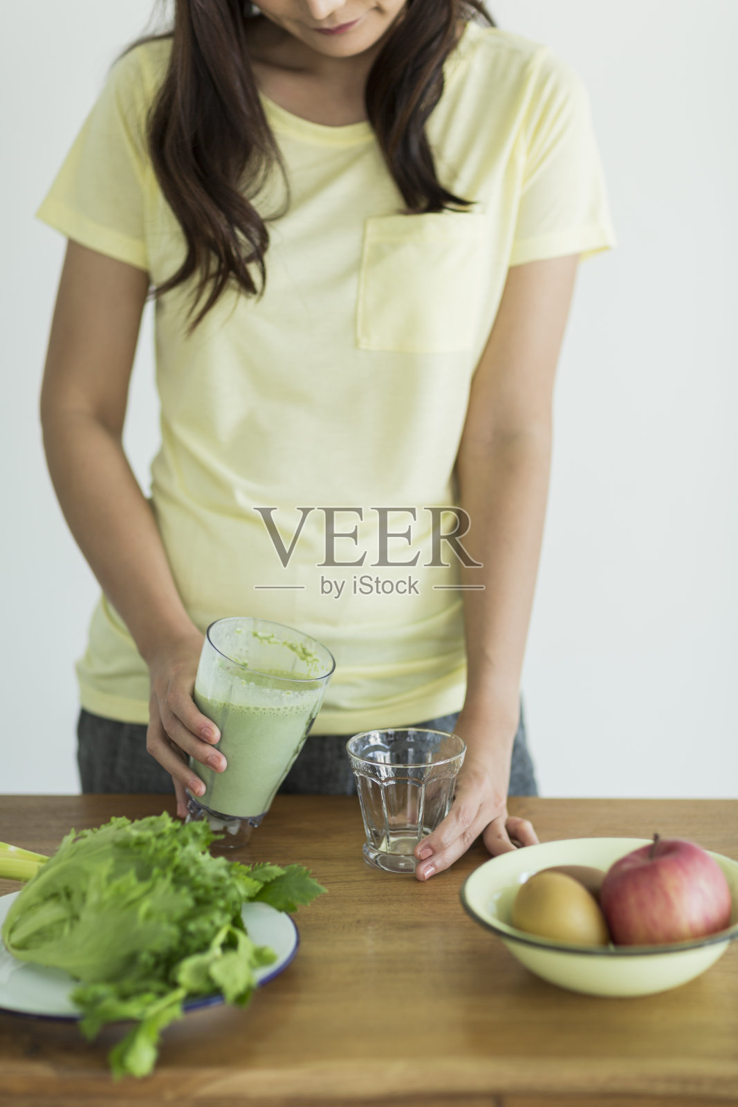 年轻女子在做绿色奶昔照片摄影图片