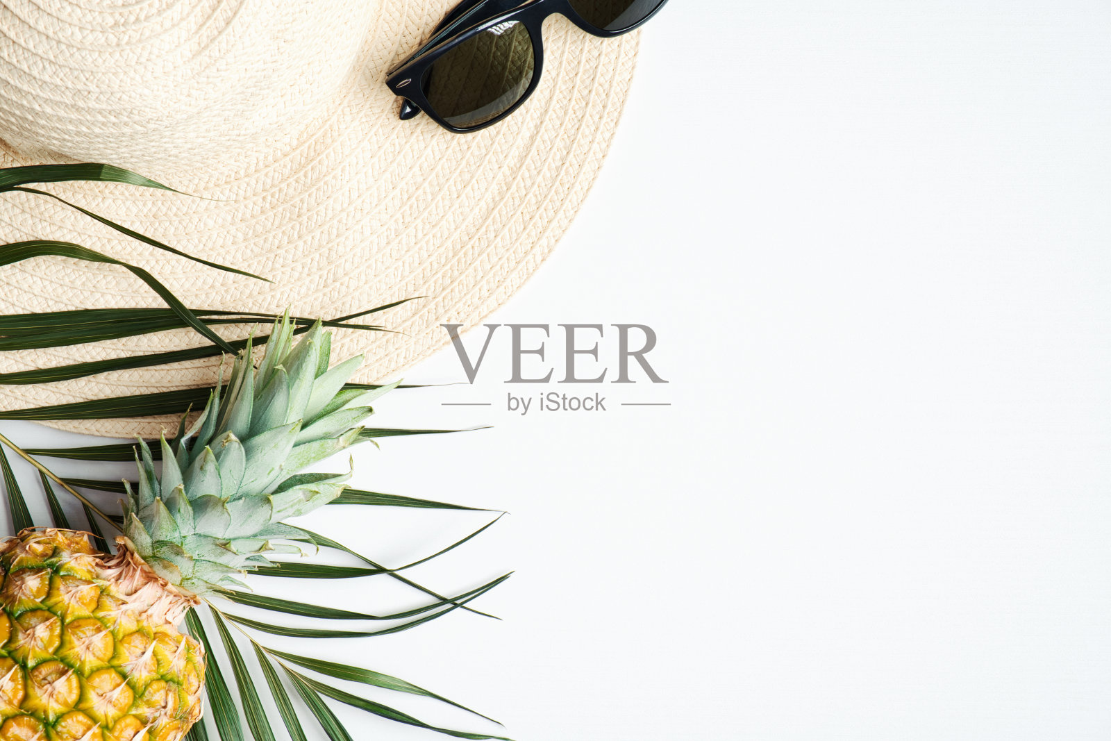 夏季旅游度假概念。顶视图女草帽，太阳镜，菠萝，棕榈叶在白色的背景照片摄影图片