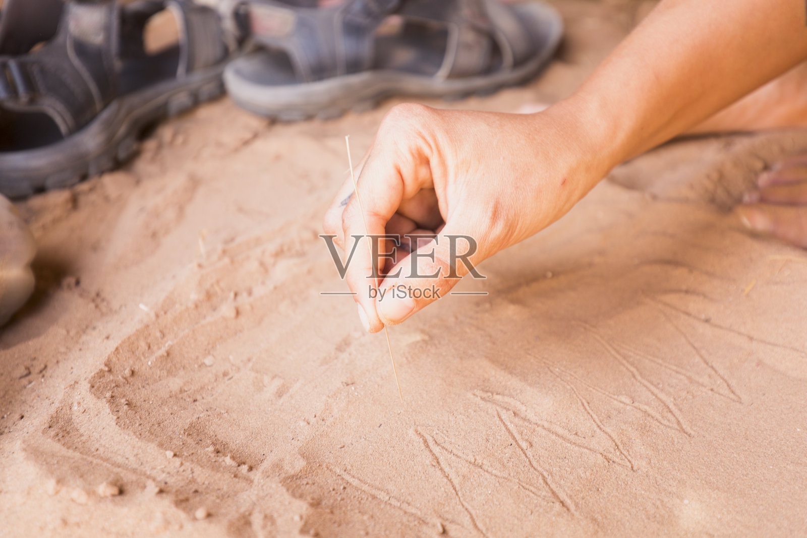 一个女人的手在M'Hamid的沙漠里。照片摄影图片