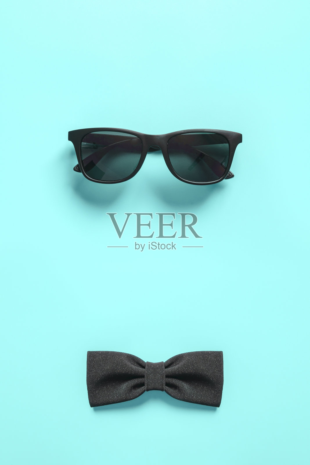 黑色时尚的太阳镜和领结在蓝色的背景。平的。照片摄影图片