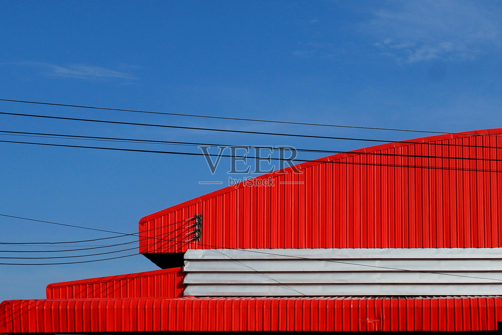 蓝色天空背景下的红色工厂屋顶。照片摄影图片