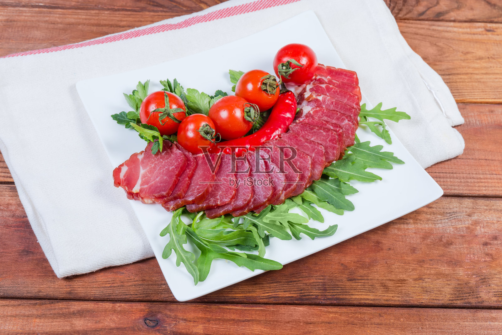 熏干猪颈肉，香草和樱桃番茄照片摄影图片