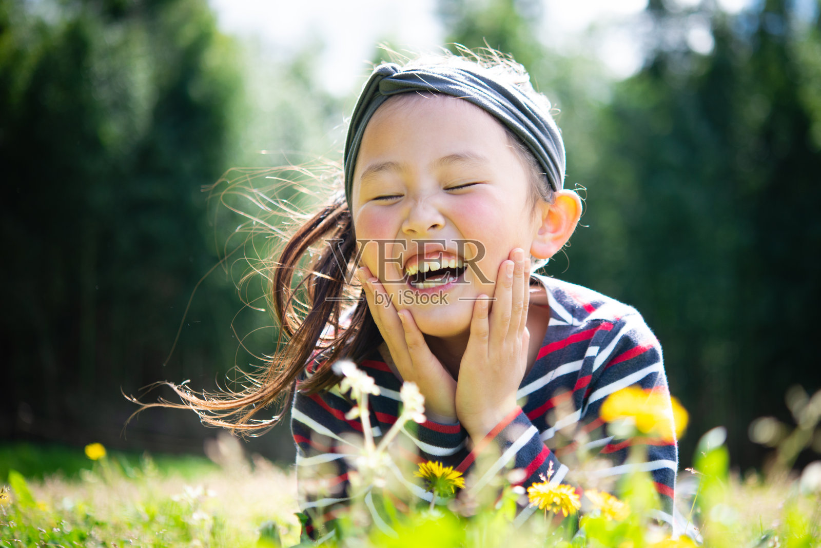 微笑的女孩躺在草地上照片摄影图片