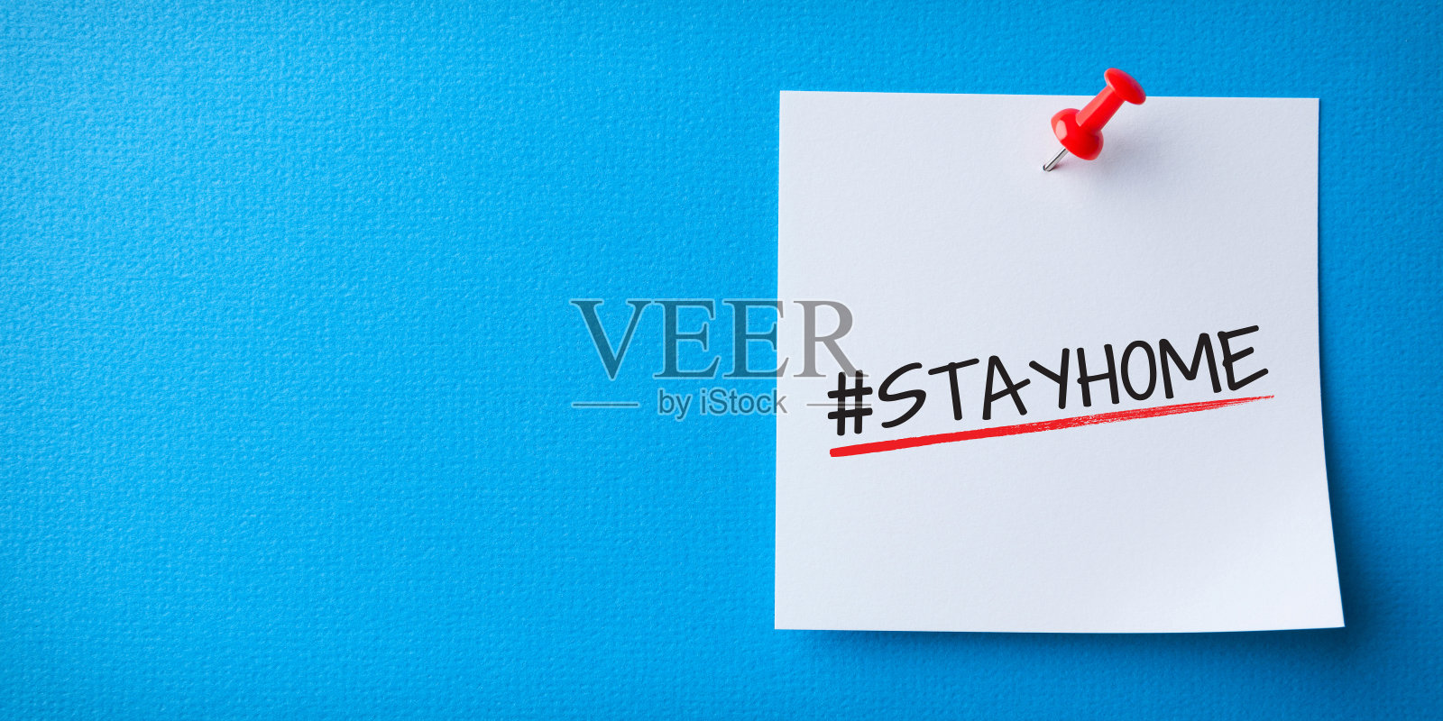 白色Sticky Note With Stay Home And Red Push Pin On Blue Background。医疗保健和医疗概念。检疫的概念。照片摄影图片