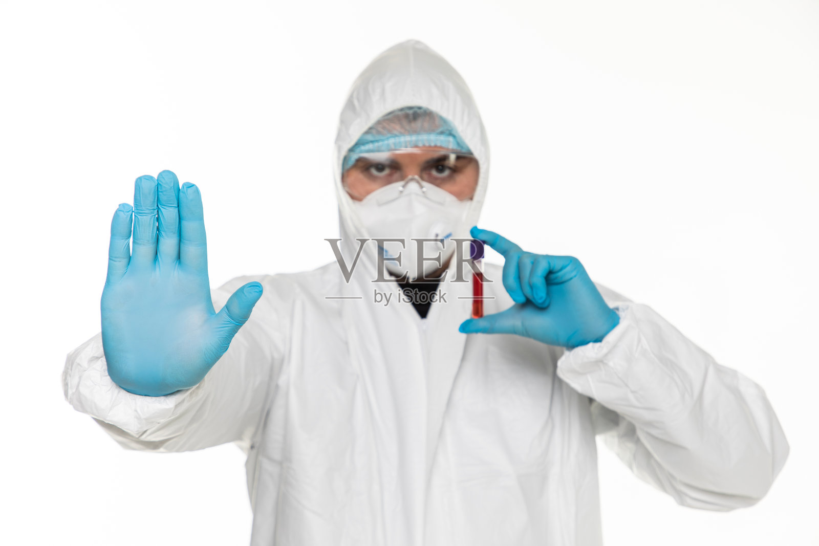 肖像的护理人员从一个科罗纳病人防护服给停止手势用他的手孤立在灰色背景。照片摄影图片