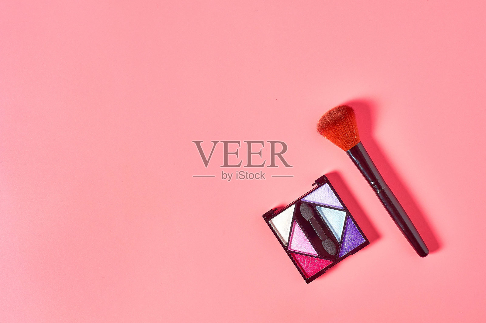 调色板的彩色腮红由天然成分附近刷化妆品粉躺在粉色的工作台上。美丽和时尚的概念。脸护理照片摄影图片