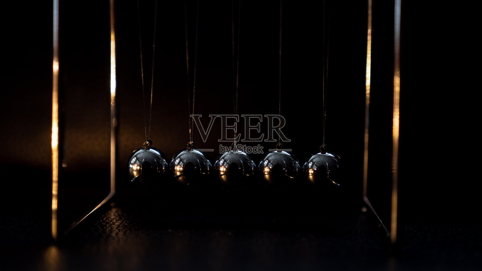 牛顿摇篮金属球移动在黑色背景照片摄影图片