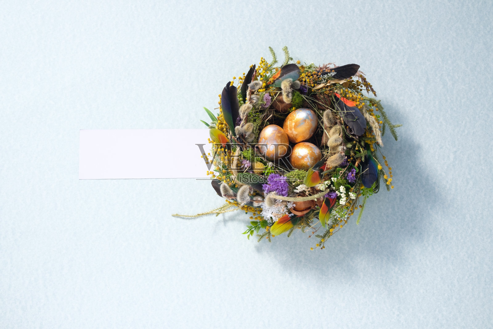 复活节静物。鸡窝中颜色混合的鸡睾丸，表面呈浅灰色。节日的概念。副本的空间。明信片设计理念。照片摄影图片