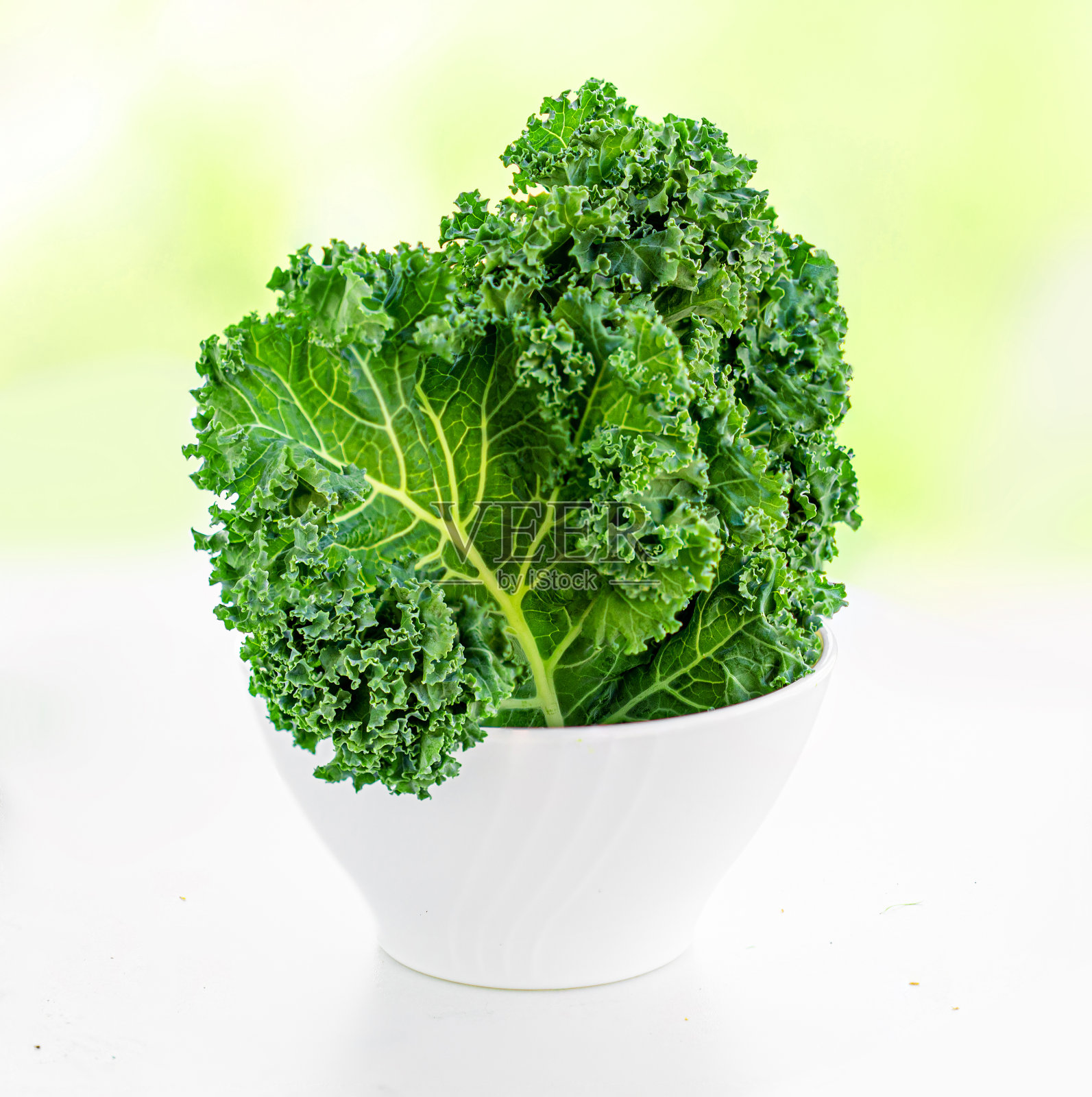 碗羽衣甘蓝沙拉孤立在白色的背景。新鲜羽衣甘蓝卷叶。食品的概念。照片摄影图片