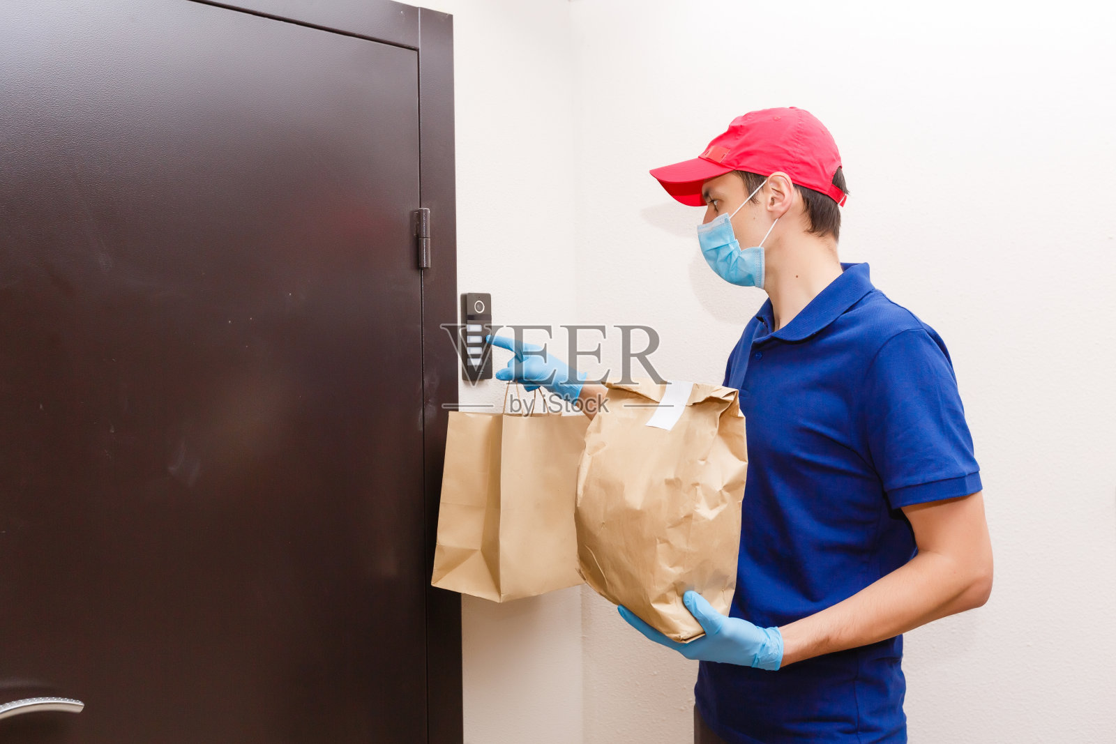 快递员带着防护口罩和医用手套送外卖。隔离、疾病爆发、冠状病毒新冠肺炎大流行情况下的配送服务。照片摄影图片