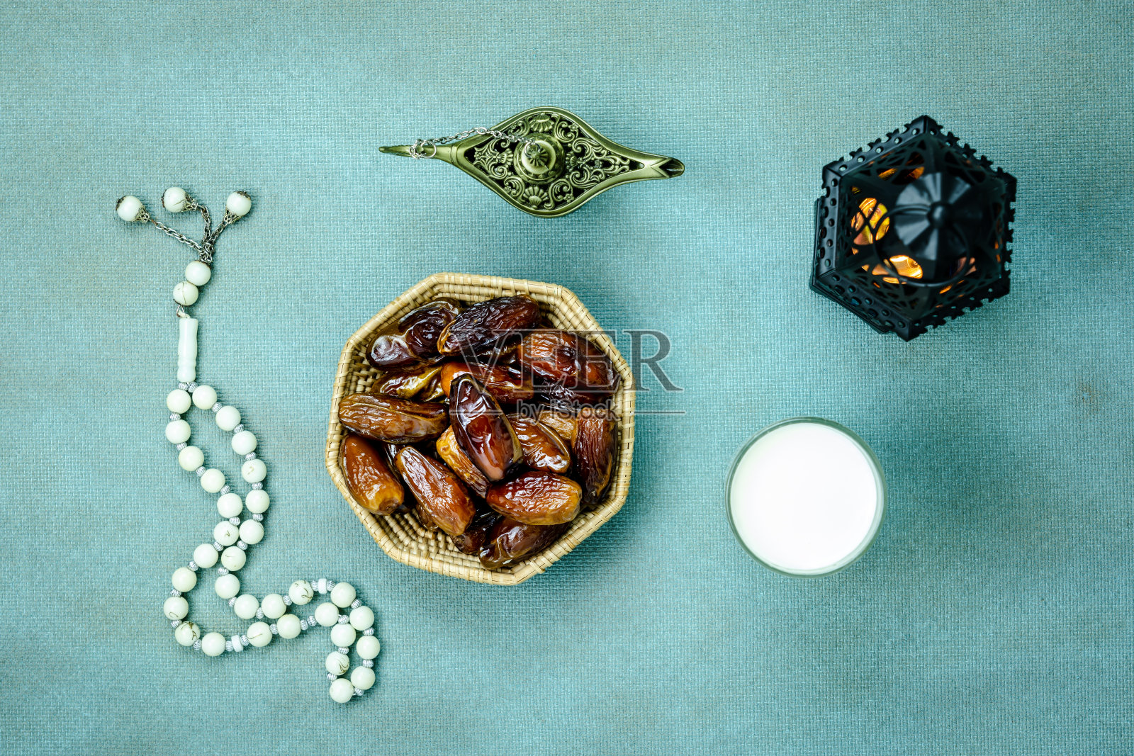 桌面上方的装饰斋月卡里姆节日背景鸟瞰图。平铺枣，念珠，点灯，一杯茶。清真膳食为斋戒是穆斯林的义务黑色木制。照片摄影图片