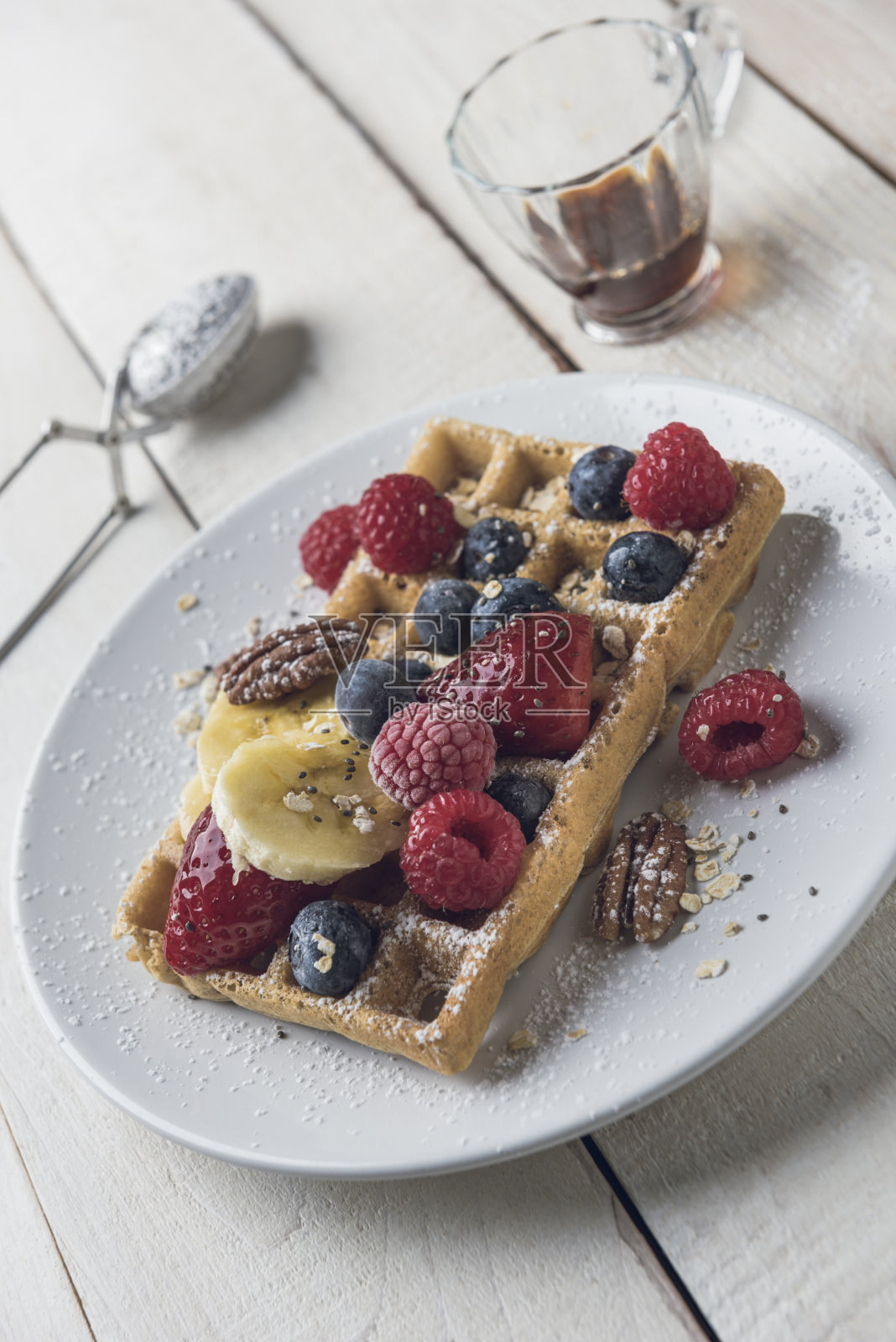 华夫饼配香蕉片、燕麦、山核桃和浆果照片摄影图片