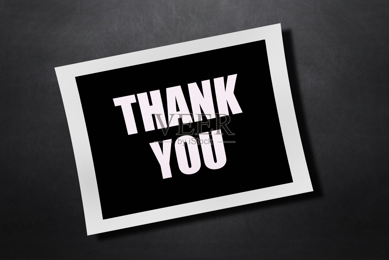 在即时胶卷纸上的感谢信。黑色的黑板背景。照片摄影图片