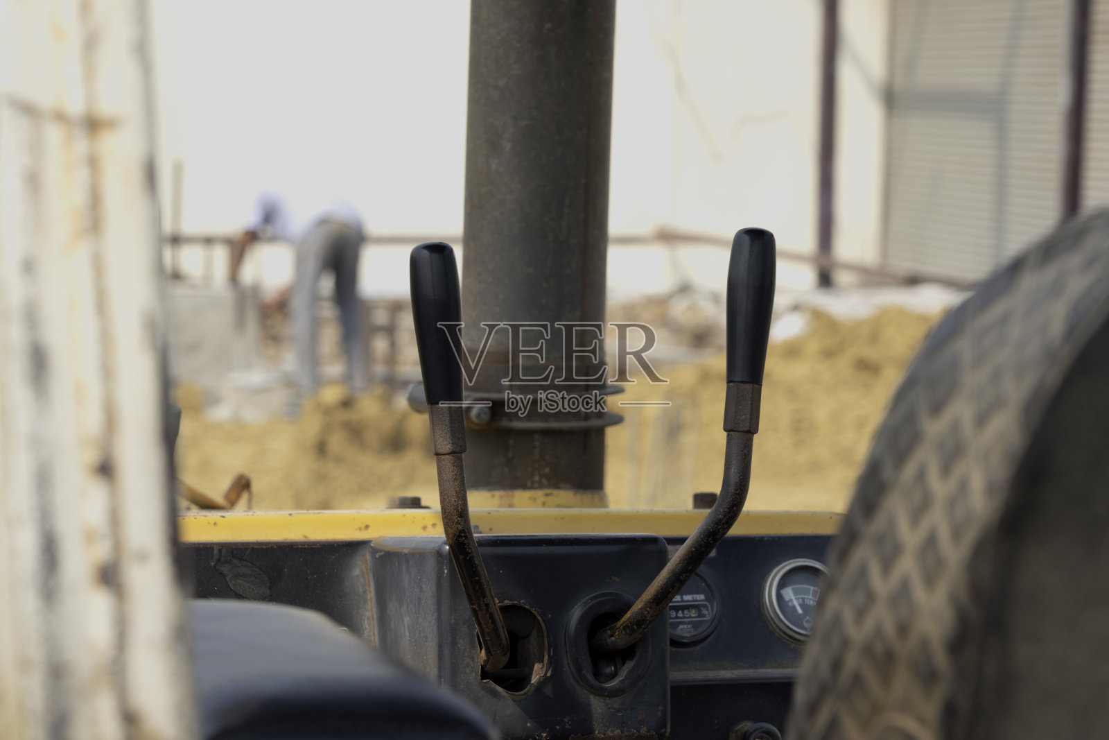 车轮后用推土机在沙地上，平整地面，修筑街道。照片摄影图片