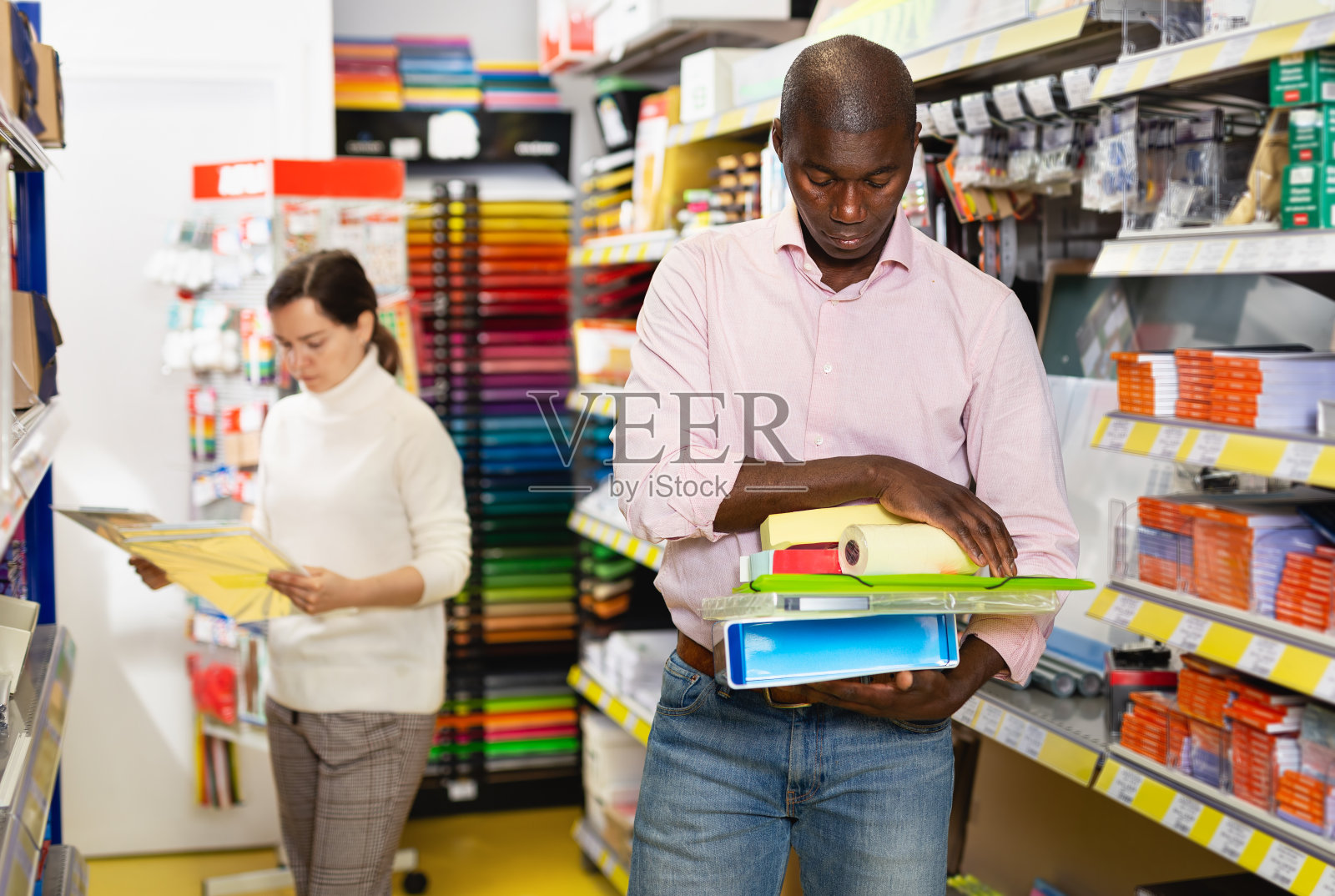 男性拿着办公文具，与女性购物照片摄影图片