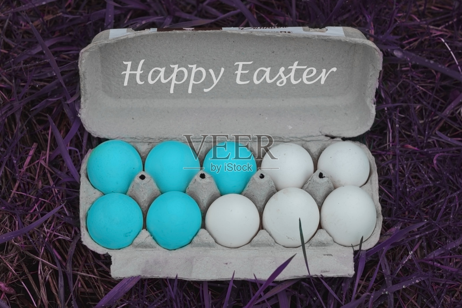 蓝色的鸡蛋在一个盒子里在紫色的草。复活节的背景。复制空间，最小样式照片摄影图片