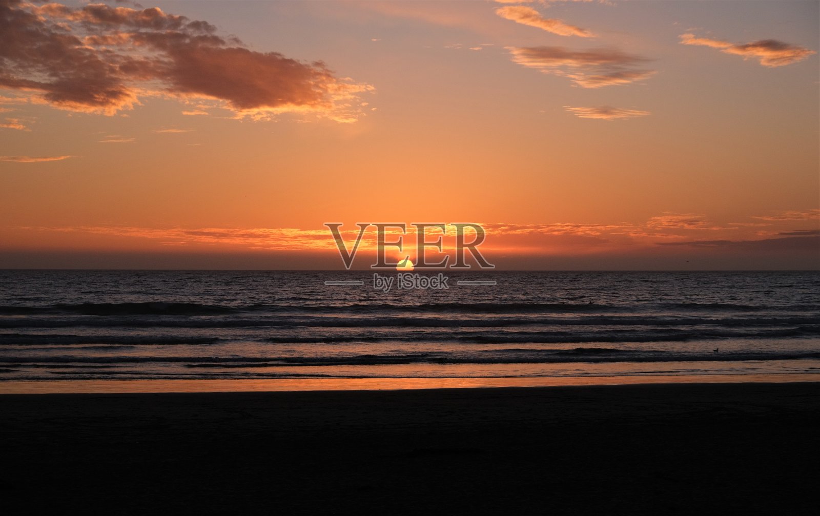 蓝色然后金色的日落在地平线上几朵云在皮斯莫海滩，加州照片摄影图片