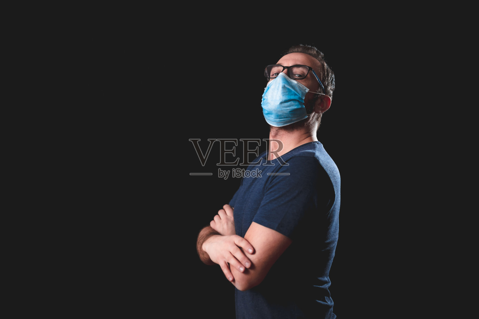 戴着防护口罩的成年人在黑色背景下摆姿势——与病毒和传染安全措施有关的社会问题。照片摄影图片