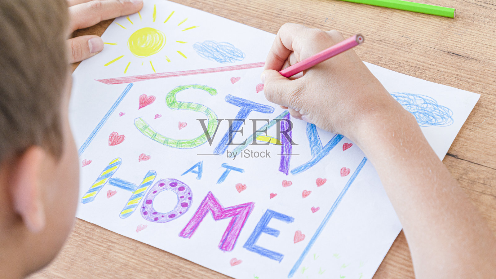 冠状病毒大流行期间居家隔离。孩子用文字画画呆在家里。社交媒体宣传预防冠状病毒照片摄影图片