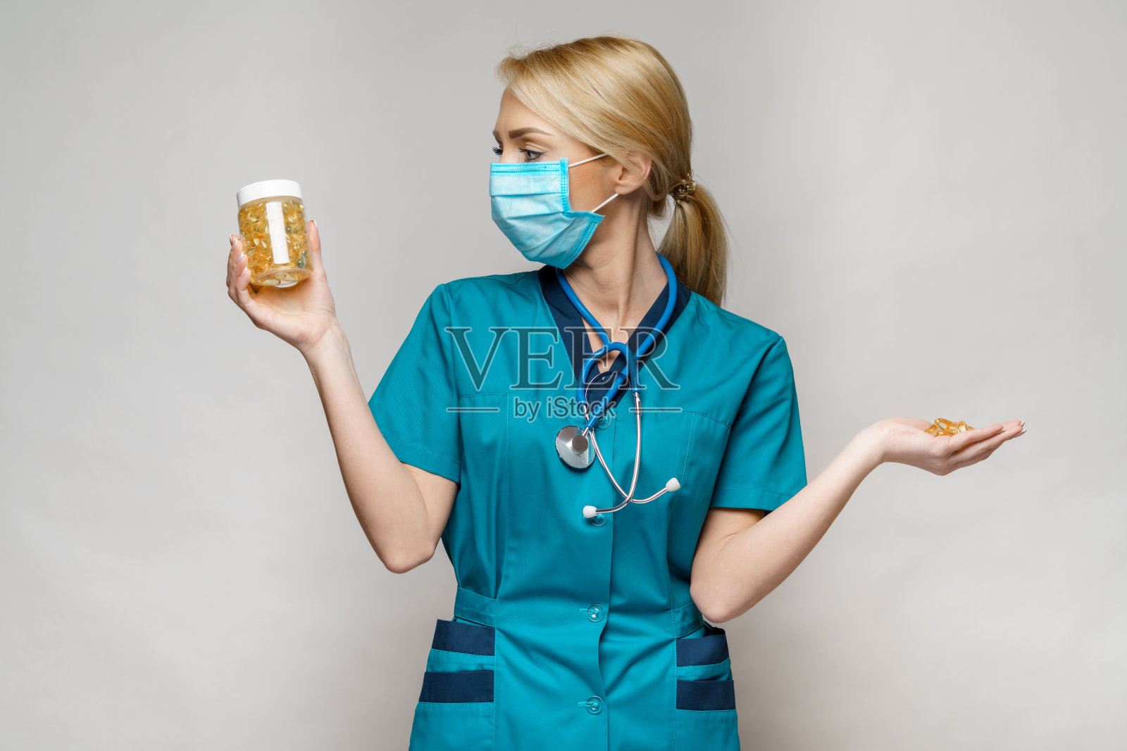 医生护士妇女戴着防护面具和橡胶或乳胶手套-持有药丸罐照片摄影图片