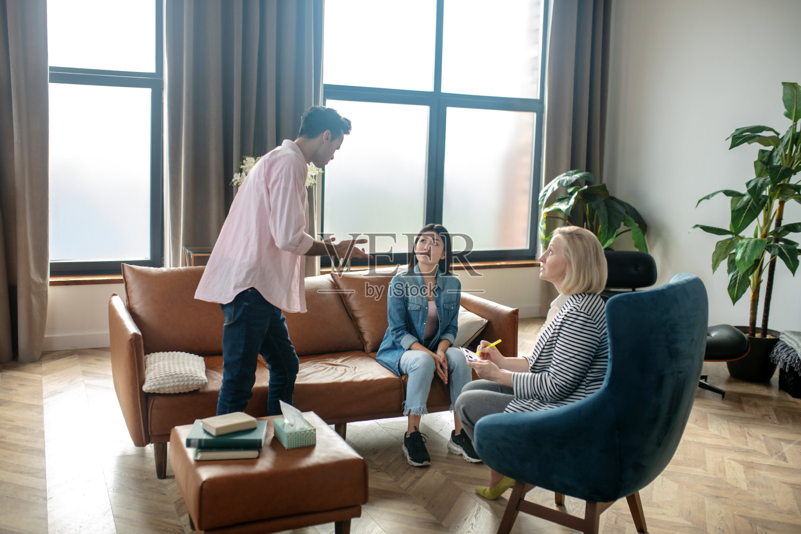 黑发高个男人站在女朋友旁边，情绪激动地向她解释着什么照片摄影图片