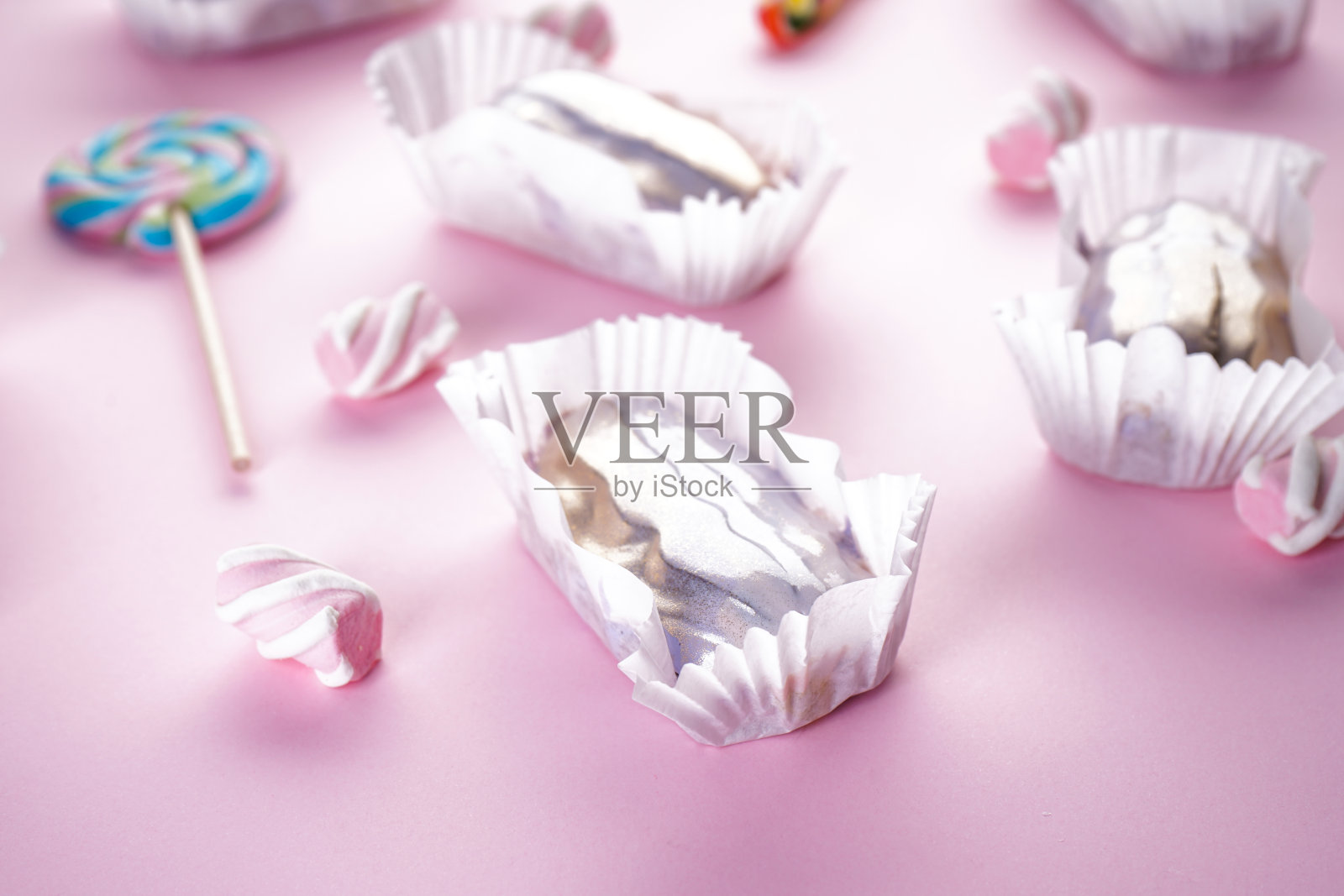 粉色背景上有糖果和棉花糖的泡芙条。法国甜点。照片摄影图片