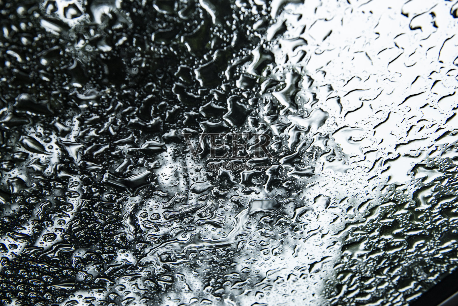 在森林场景中，雨滴聚集在挡风玻璃上照片摄影图片