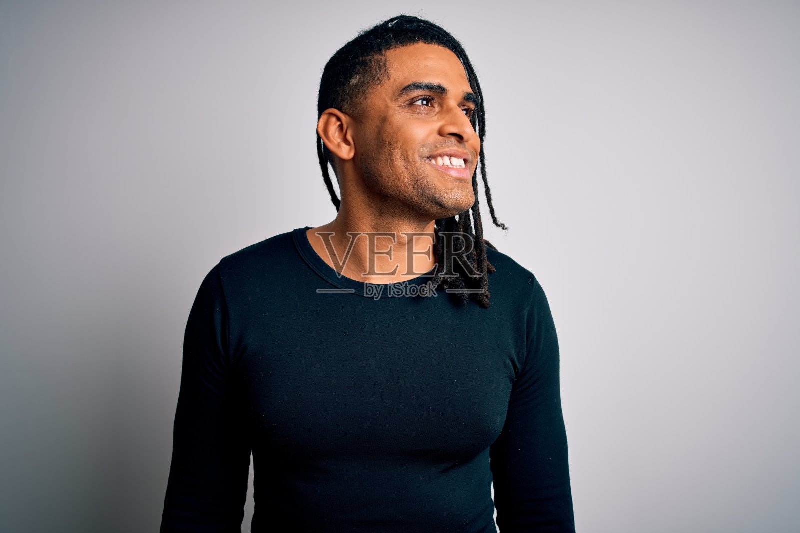 年轻英俊的非洲裔美国人与雷鬼发穿着黑色休闲毛衣看向一边与微笑的脸，自然的表情。自信的笑。照片摄影图片