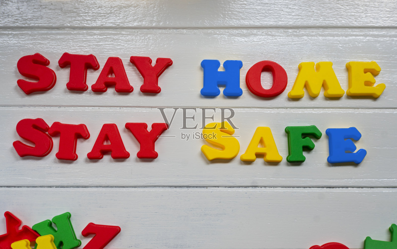 留在家里，保持安全标志和符号，塑料字母在白色木材背景照片摄影图片