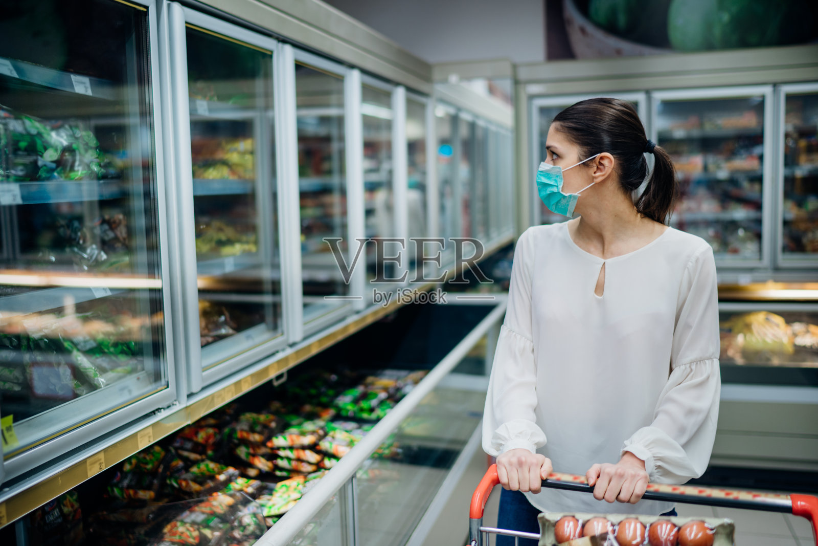 在超市买口罩的女人。2019冠状病毒病大流行期间的恐慌性购物。在供应商店预算购买。购买冰箱智能购买家庭食品杂货照片摄影图片