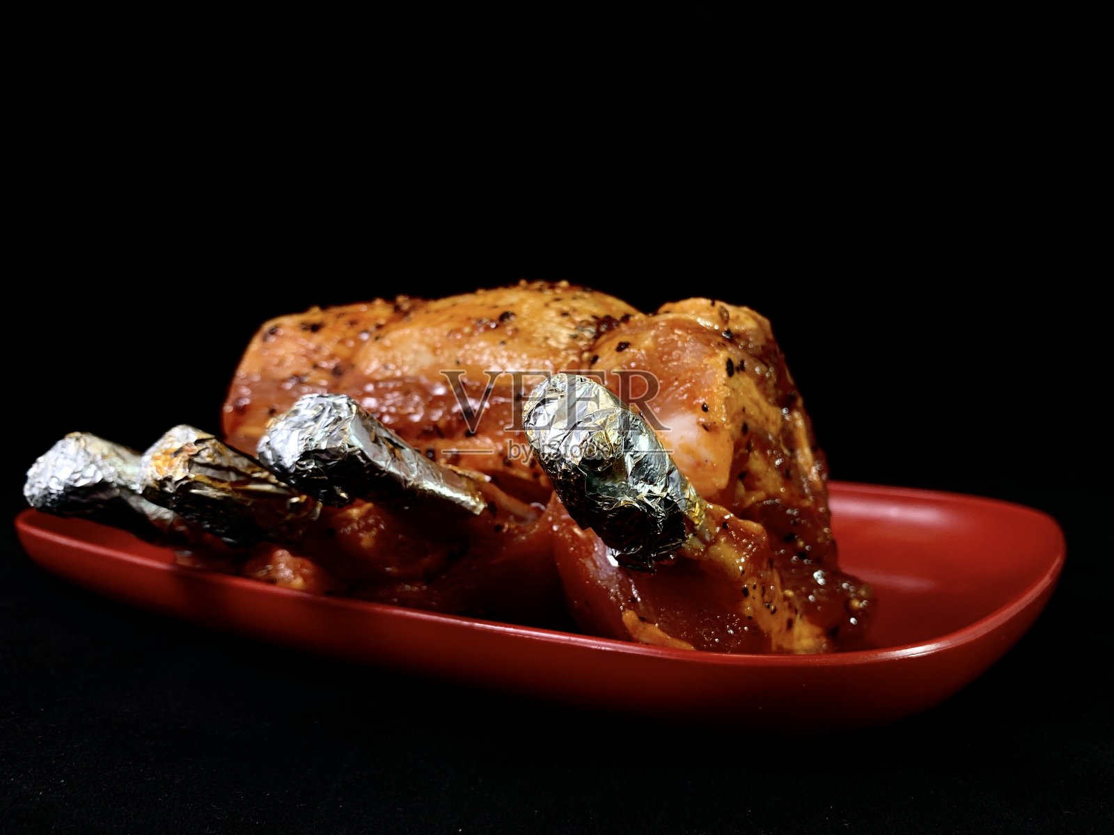 黑色背景上的一大块炸肉。用火烹饪的辣排骨。用烤箱烤的猪肉和小牛肉。照片摄影图片