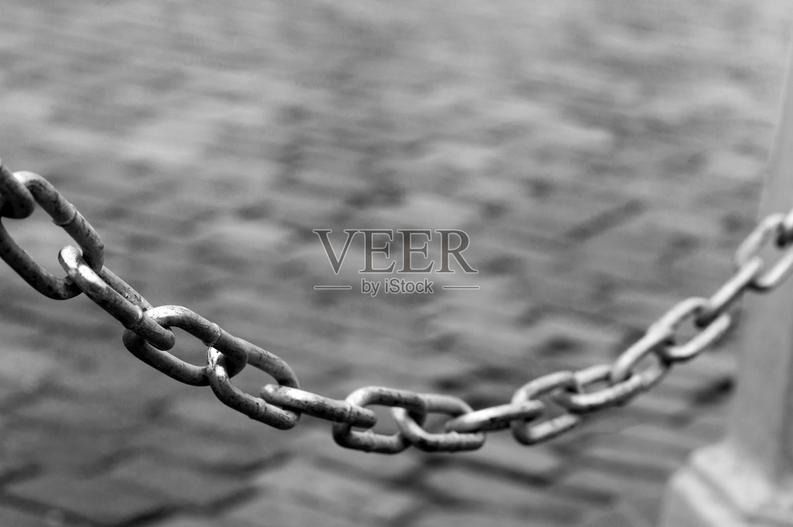 金属链固定在混凝土支架上。禁止和限制进入的概念。黑白图像照片摄影图片