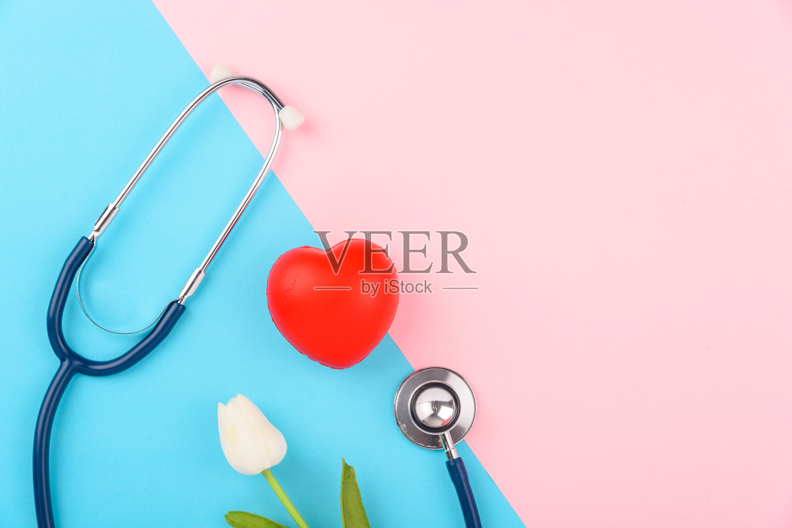 医生日概念，平躺俯视图，听诊器与红心粉红色的蓝色背景，心脏病诊断与复制空间的文本照片摄影图片