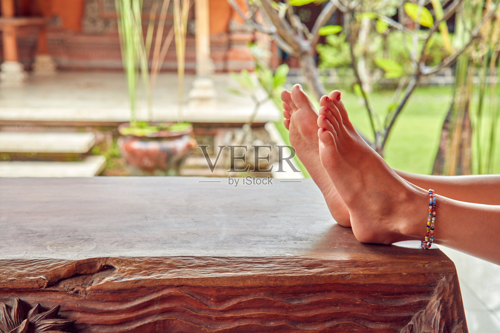 花园露台放松时放在桌上的女人的脚照片摄影图片
