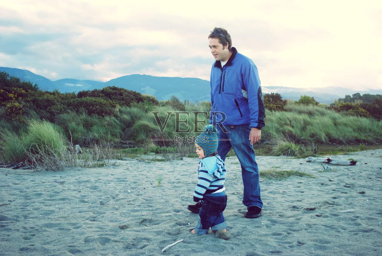 父亲和孩子在冬天的海滩照片摄影图片