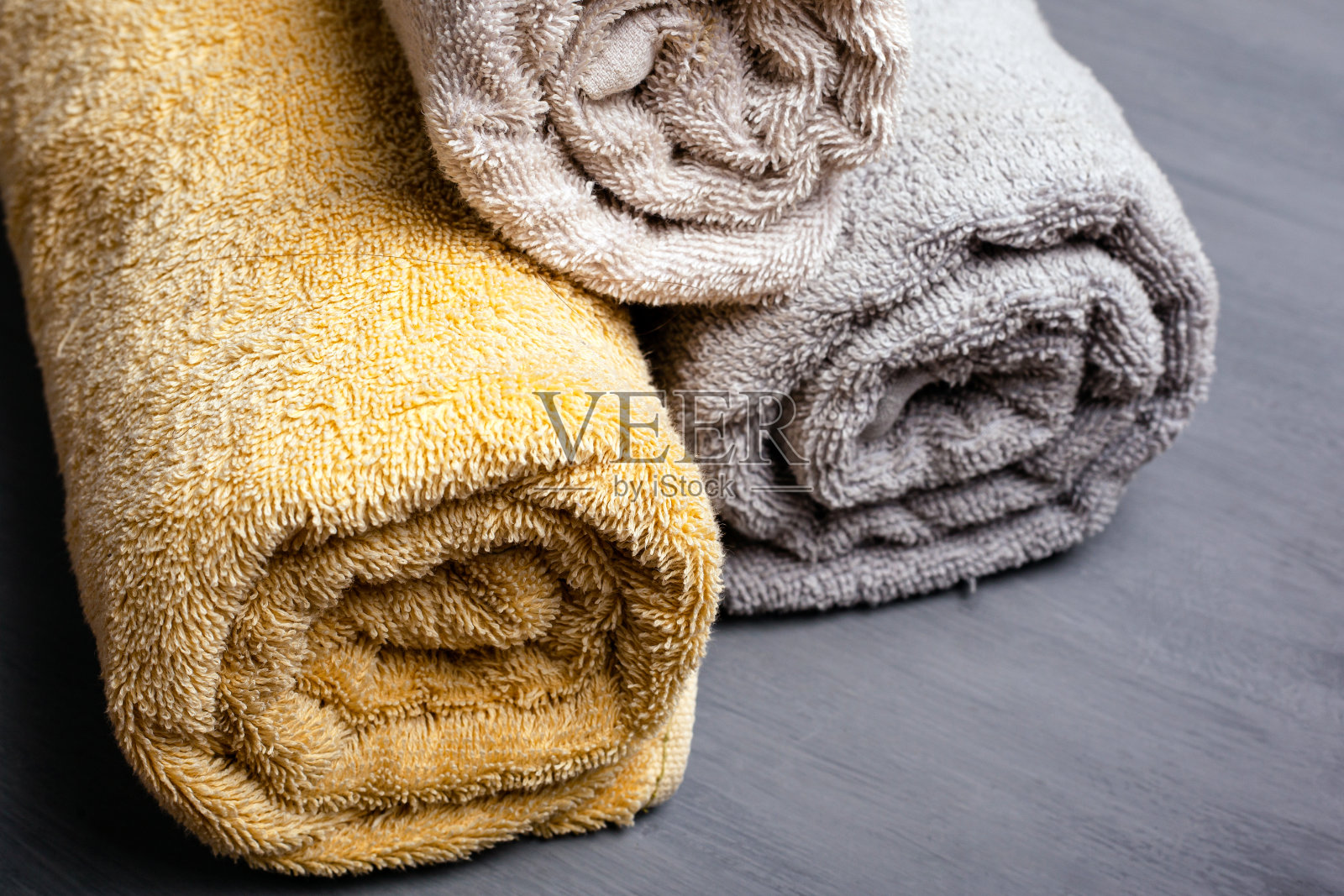 三卷折叠毛巾柔和的颜色在一个灰色的背景特写照片摄影图片