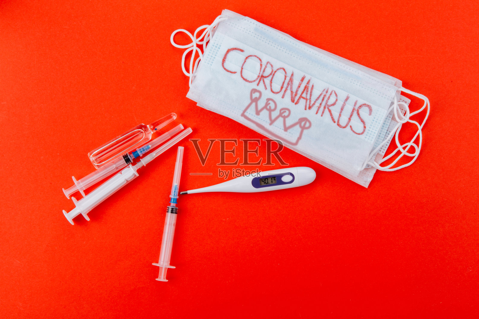 红色背景刻有冠状病毒字样的医用防护口罩照片摄影图片