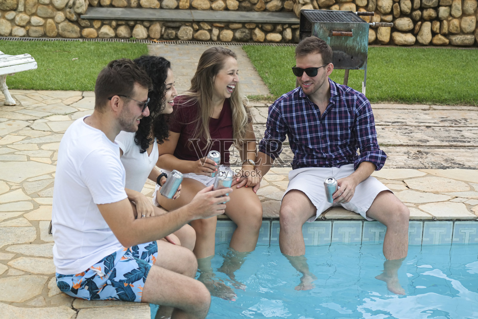 一群朋友在泳池边拿着银罐啤酒照片摄影图片