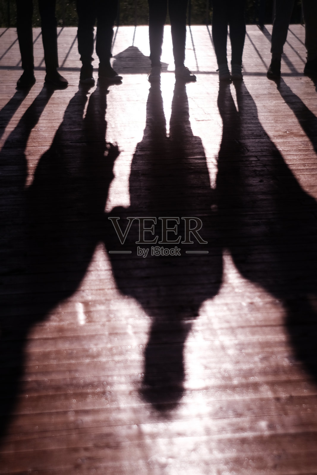 比赛是团队合作。影子里的人牵着手互相跟随，培养团队精神照片摄影图片