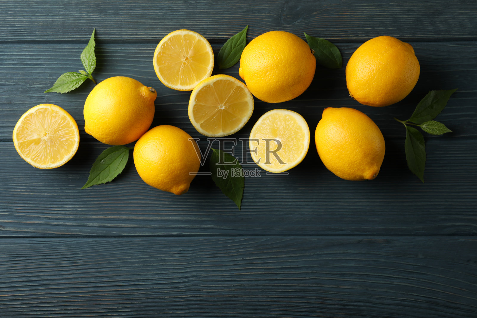 木质背景上的新鲜柠檬，俯视图。成熟的水果照片摄影图片