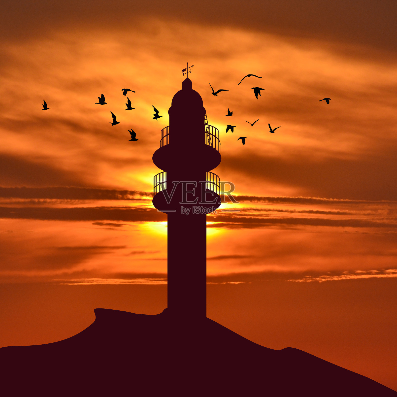 灯塔的轮廓和鸟儿在它周围飞翔照片摄影图片