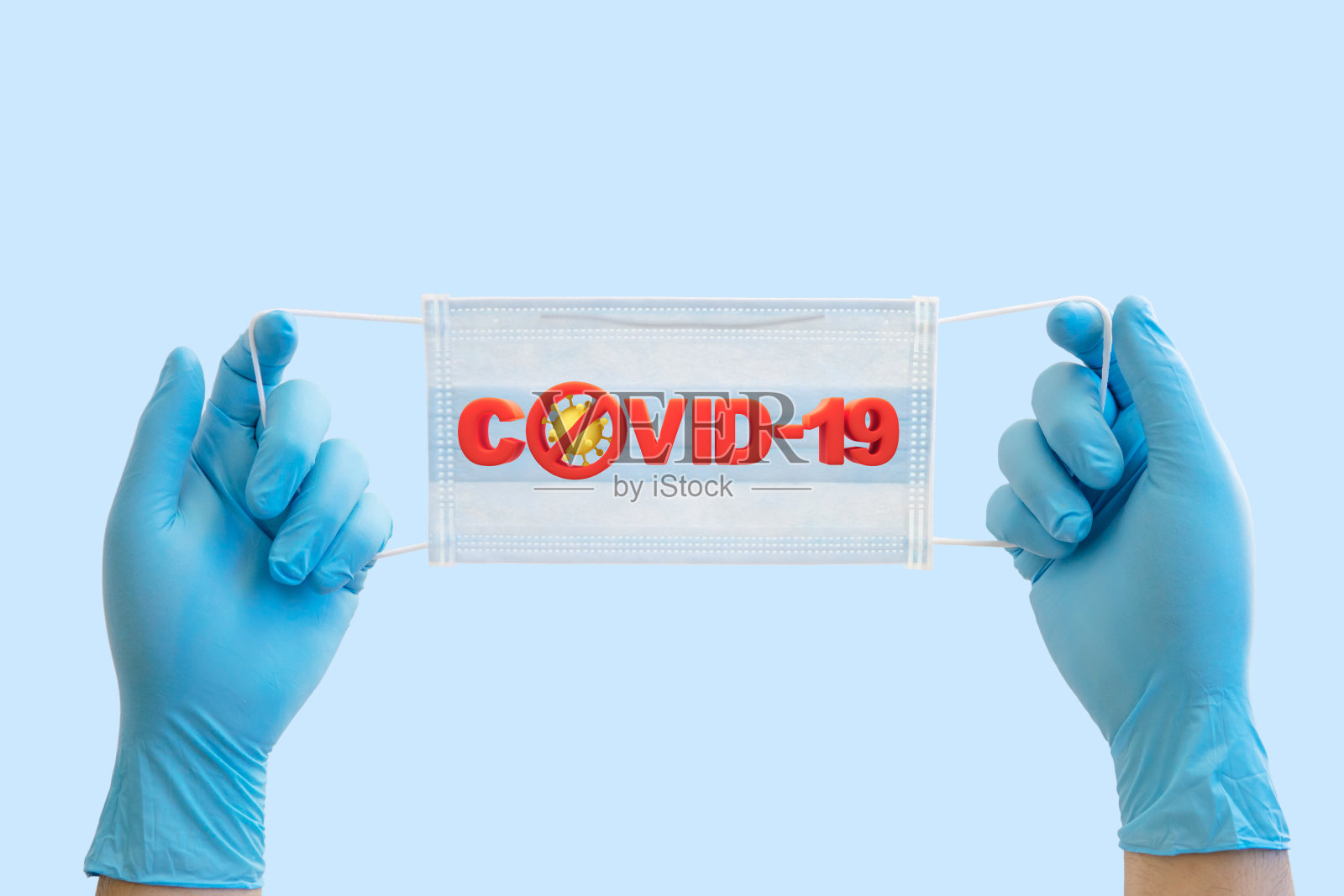 医生手持带有covid-19字样的外科口罩，浅蓝色背景上有阻止covid-19传播的标志照片摄影图片