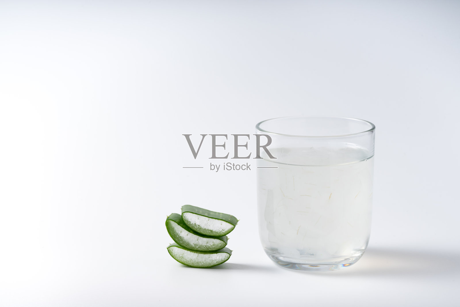 切芦荟茎和凝胶在木碗上白色背景，健康食品饮料和护肤美容理念，复制空间照片摄影图片